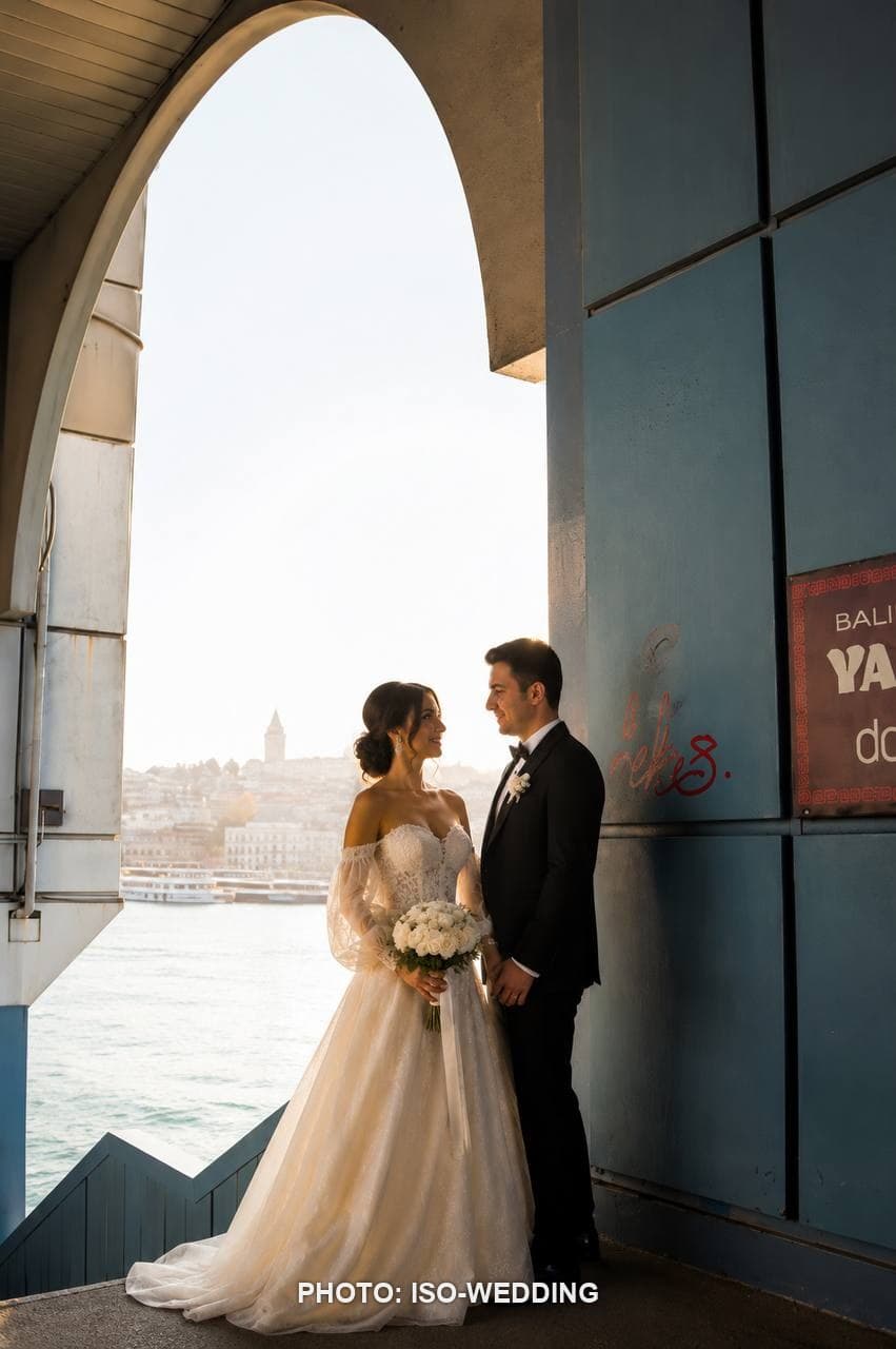 Altın saatte Galata Köprüsü'nde, arka planda Galata Kulesi silüetiyle gelin ve damat